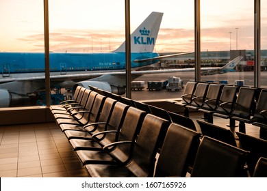 Amsterdam, Netherland - December, 2019: Empty seats in airport with KLM Airline airplane in background