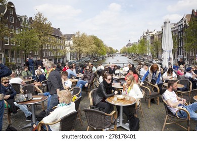 Amsterdam, Netherlands, 10 May 2015: People Enjoy Nice Spring Day On A Bridge Over Singel Canal In Amsterdam