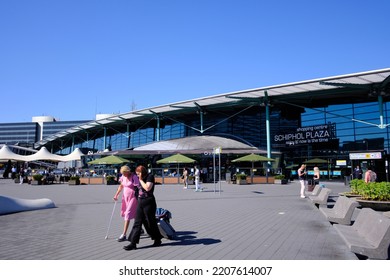 Amsterdam, The Netherlands - August 10 2022: A Couple Walking Away From Amsterdam Schiphol Airport On Sunny Day.