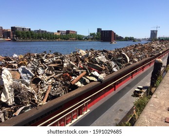 Amsterdam, the Netherlands - August 21 2017: metal scrap piled onto barge for transport to processing depot