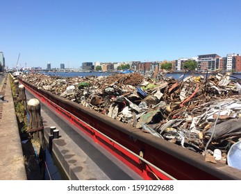 Amsterdam, the Netherlands - August 21 2017: metal scrap piled onto barge for transport to processing depot