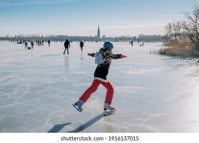 Amsterdam, Netherlands - February 13 2021: People of the Netherlands ice scating on a natural frozen lake in winter