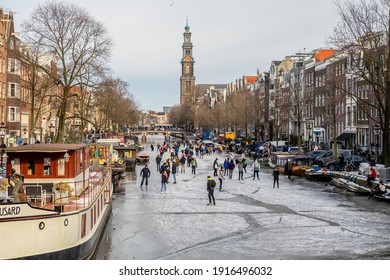 Amsterdam, Netherlands - February 14 2021: People Ice Scating On Frozen Canal In City Center Of Amsterdam