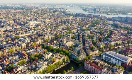 Amsterdam, Netherlands. Flying over the city rooftops towards Amsterdam Central Station ( Amsterdam Centraal ), Aerial View  
