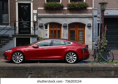AMSTERDAM, NETHERLANDS - JULY 10, 2017: Electric Tesla Model S car parked by the canal in Amsterdam. Netherlands has 528 registered cars per 1,000 inhabitants.