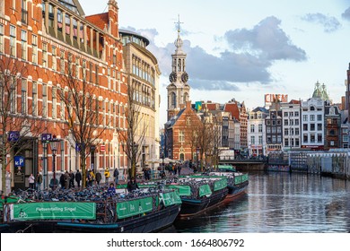 AMSTERDAM, NETHERLANDS - March 04, 2020: Beautiful winter cityscape view of the Singel canal (Singelgracht) in Amsterdam near the flower market and shopping street Kalverstraat, Holland.
