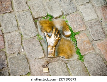 Amsterdam, The Netherlands, May 2011: Monument to prostitutes in the Red Light District. Among the paving stones poured composition where the hand holds the female breast.