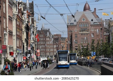 Amsterdam, The Netherlands - May 23, 2019: Trams and people on bicycles near Dam square in central Amsterdam, The Netherlands on May 23, 2019