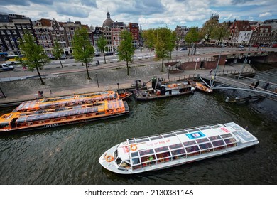 AMSTERDAM, NETHERLANDS - MAY 9, 2017: Aerial View Of Amsterdam Canal With Tourist Boats Near Amsterdam Centraal