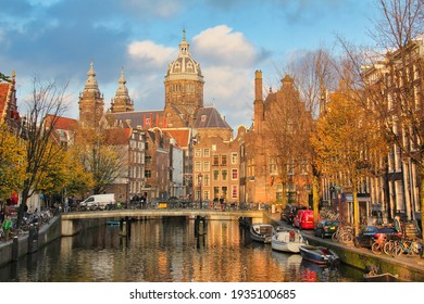Amsterdam, The Netherlands - November 12, 2015: Canal with autumn trees and St. Nicholas church in the background in historical Amsterdam, on November 12, 2015 in Amsterdam, The Netherlands. - Shutterstock ID 1935100685