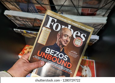 AMSTERDAM, NETHERLANDS - OCTOBER 08, 2018: Forbes magazine with Jeff Bezos on the cover in a hand. Jeff Bezos is president of Amazon. Forbes is an American family-controlled business magazine.