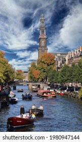Amsterdam, The Netherlands - October 16, 2016: Tower of the Westerkerk church, autumn trees and people boating in a canal in Amsterdam, The Netherlands on October 16, 2016