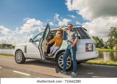 AMSTERDAM, NETHERLANDS - SEPTEMBER 02, 2017: Family Of Mother And Son Posing In A Fuji White SUV Landrover Range Rover Vogue 2011 Model Parked At A Roadside During Summer 