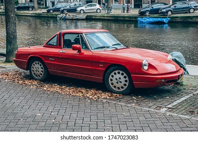 Amsterdam, Paises Bajos; October 26, 2019: Red and dusty Alfa Romeo Spider parked in the street - Shutterstock ID 1747023083