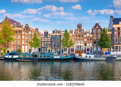 Amsterdam. Panoramic view of the historic city center of Amsterdam. Traditional houses and bridges of Amsterdam. An early quiet morning and the serene reflection of houses in the water.  Europe