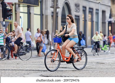 AMSTERDAM-AUG. 19, 2012. Girl on a rental bike near Dam Square. 38% of traffic movement in the city is by bike , 37% by car, 25% by public transport. In the center, 57% of traffic movement by bike.