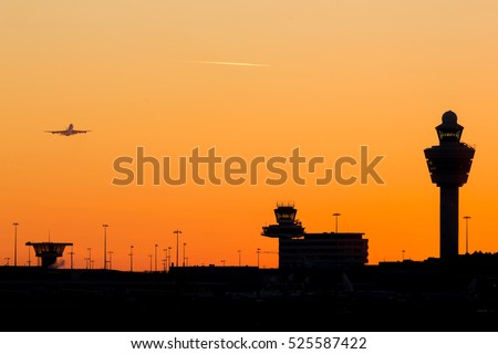 Amsterdam-Schiphol airport skyline sunset at a clear sky with airplane