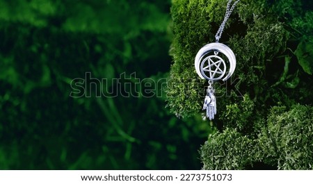 amulet with pentagram on moss, abstract natural forest background. spiritual ritual. witchcraft, pagan traditions, wiccan practice. esoteric symbol of pentacle and hand. copy space
