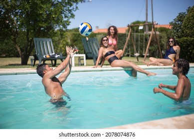 Amused friends playing ball in pool. Young women and men in swimsuits in swimming pool, having fun. Leisure, friendship, party concept - Powered by Shutterstock