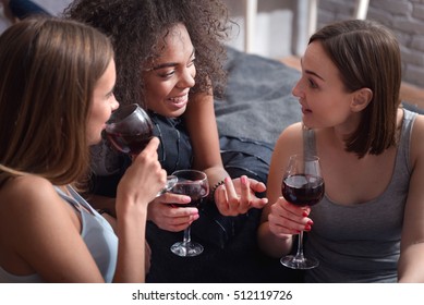 Amused Girls Drinking Wine And Having Exciting Conversation