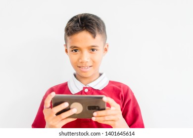 Amused teenager boy playing games on smartphone.Portrait of teenage gamer boy playing video games on smartphone