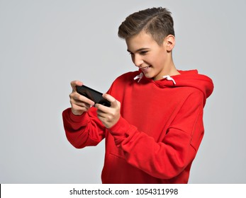 Amused teenager playing games on smartphone   - posing at studio
 - Powered by Shutterstock