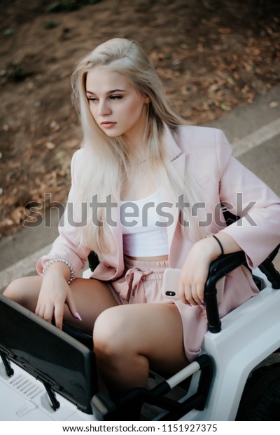 Amusement Park. Games. Holiday. Vacation. Game\
machine. baby machine. Smiling woman driving car, attractive girl\
sitting in automobile. summer portrait. Girl Riding a Car In\
Amusement Park\
Outdoor