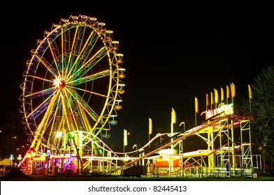 Amusement Park At Night - Ferris Wheel And Rollercoaster
