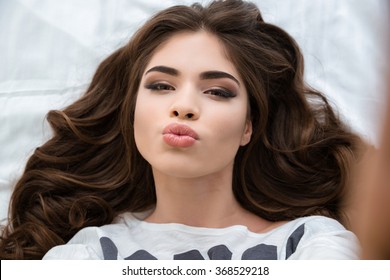 Amusing Charming Young Woman Taking Selfie And Making Duck Face Over White Background