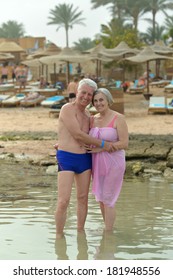 Amusing elderly couple having rest on beach