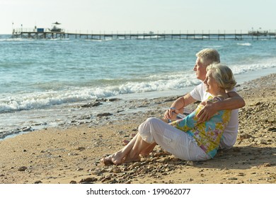 Amusing elderly couple having rest on beach