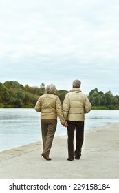 Amusing elderly couple having rest near river