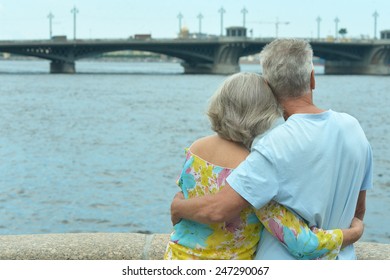 Amusing elderly couple having rest near river