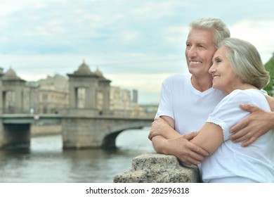 Amusing elderly couple having rest near river