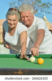 Amusing Old Couple On Vacation Playing Billiards