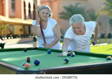 Amusing Old Couple On Vacation Playing Billiards