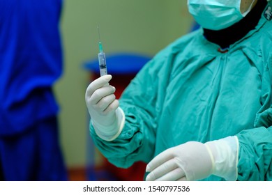 Anaesthetist Preparing Intravenous Drugs In A Syringe Under Full Aseptic Technique.