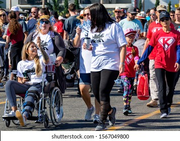 Anaheim, CA / USA - Nov 3, 2019: Happy Young Woman With A Tattooed Arm And Sitting In A Wheelchair Is Pushed By A Friend As They Start The Walk With The Crowd At The 2019 JDRF One Walk Fundraiser. 