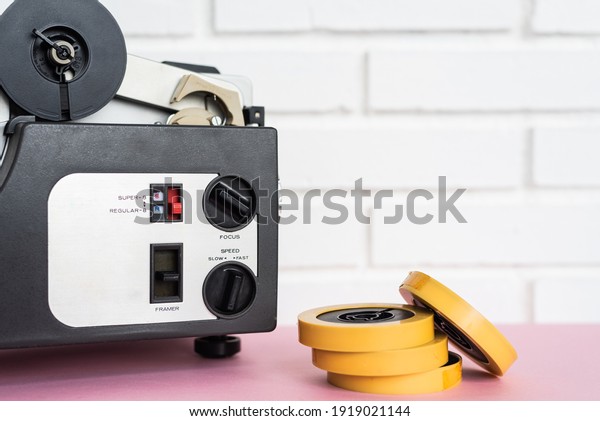 Analog audio device and tapes placed on table near\
white brick wall at home