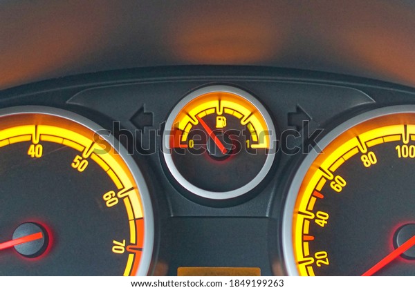 Analog car\
dashboard fuel gauge with yellow\
lights