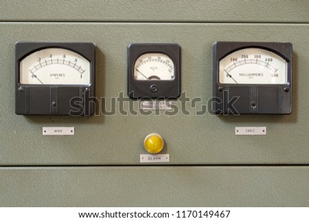 Analog dials on wall panels showing current and volts.