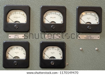 Analog dials on wall panels showing current and volts.