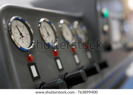 Analog manometers on a control panel of industrial machine. Selective focus.
