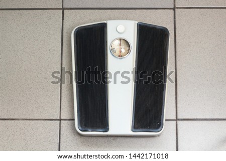 analog mechanical old retro bathroom weight scale on floor on a gray tile close up. Diet weight control. 