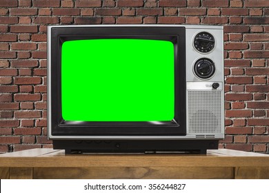 Analog television with brick wall and chroma key green screen.