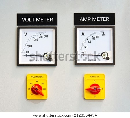 Analog voltmeter and amp meter with dial and arrow. Indoor electrical control panel. Indoor electrical current control panel.