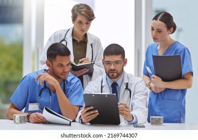 Analysing Patient Records Together. Shot Of A Group Of Medical Practitioners Working Together In A Hospital Boardroom.