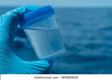 Analysis Of A Sample Of Sea Water, Ocean. The Scientist In The Glove Took Water In A Jar