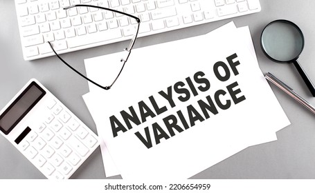 ANALYSIS OF VARIANCE text on a paper with keyboard, calculator on grey background