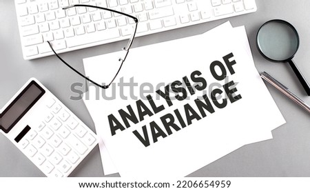 ANALYSIS OF VARIANCE text on a paper with keyboard, calculator on grey background